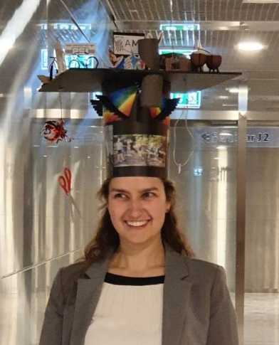 Young women facing the camera and wearing a crafted Doctoral hat.